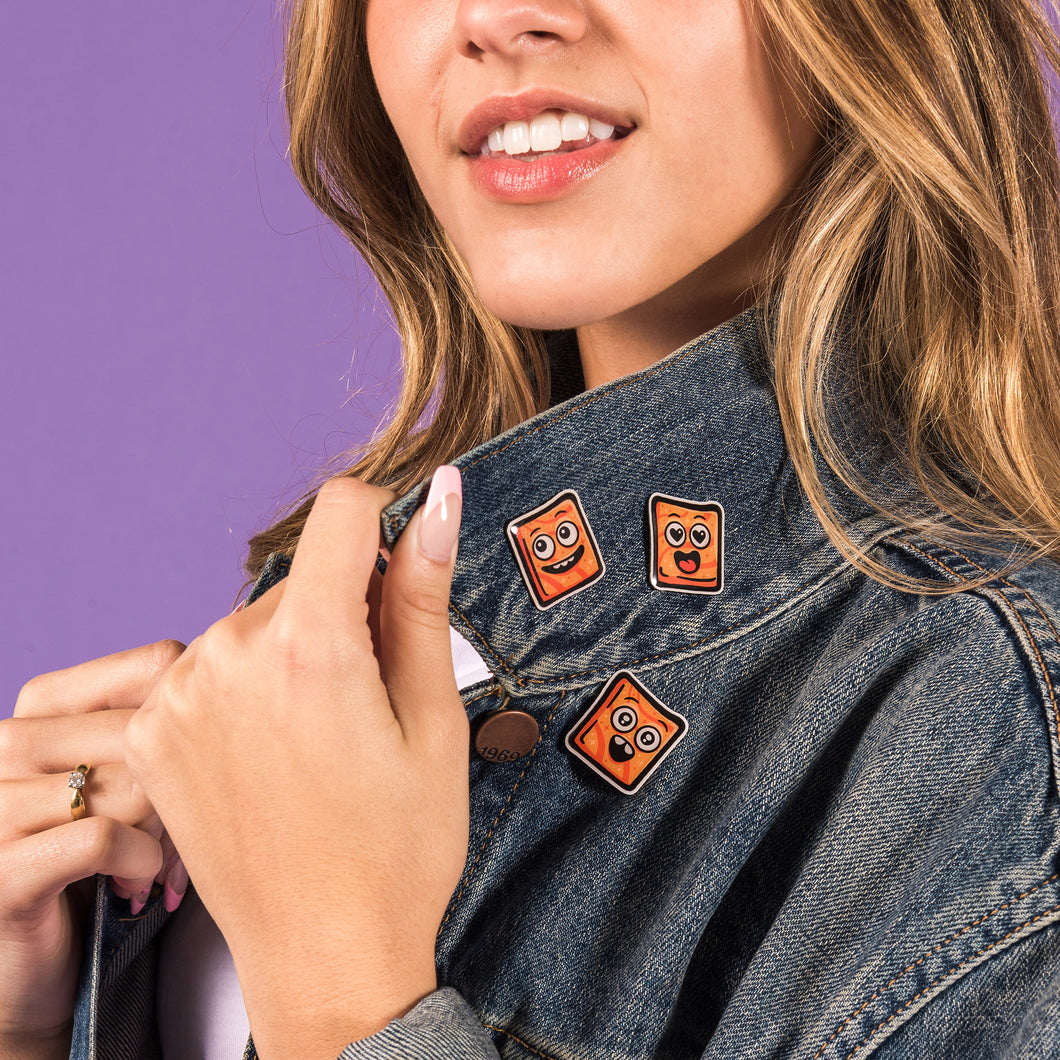 Young woman wearing three Cinnamon Toast Crunch Cinnamoji Pins on her denim jacket.